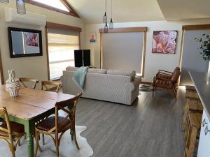 a living room with a couch and a table at Daysend Cottages in Merrijig