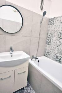 a bathroom with a sink and a mirror and a tub at Moderny byt, 300 m do centra mesta in Košice