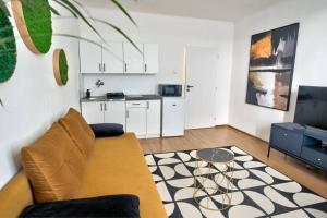 a living room with a couch and a kitchen at Moderny byt, 300 m do centra mesta in Košice