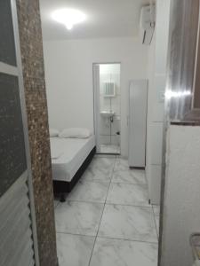 a small room with a bed and a bathroom at Casa Dunas Cabo Frio in Cabo Frio