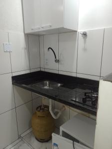 uma pequena cozinha com um lavatório e um fogão em Casa Dunas Cabo Frio em Cabo Frio