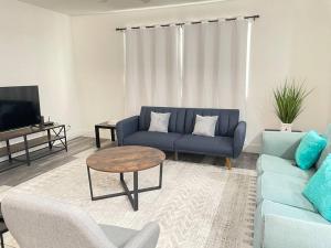 3Bedroom 2Bath 15 Min to strip 10 downtown في لاس فيغاس: غرفة معيشة مع أريكة زرقاء وطاولة