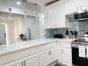 a white kitchen with white cabinets and a stove at 3Bedroom 2Bath 15 Min to strip 10 downtown in Las Vegas