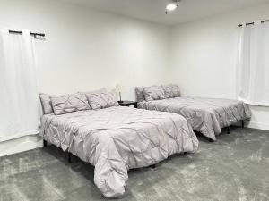 3Bedroom 2Bath 15 Min to strip 10 downtown في لاس فيغاس: سريرين في غرفة بجدران بيضاء