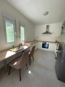 a kitchen with a table and chairs and a refrigerator at Adriatic Family House in Utjeha