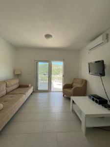 a living room with a couch and a tv at Adriatic Family House in Utjeha