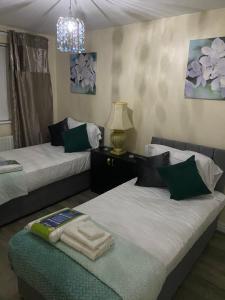 a bedroom with two beds and a chandelier at Rehoboth guest house in Manchester