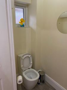 a small bathroom with a toilet with a window at Rehoboth guest house in Manchester