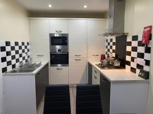 a kitchen with white cabinets and a stove top oven at Rehoboth guest house in Manchester