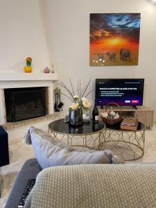 un soggiorno con un divano e una TV di Villa Avras sea view feel like home properties a Saronida