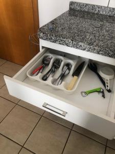 a drawer filled with kitchen utensils under a counter at Apartamento Giardino 212 sem parques in Rio Quente