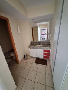 a small bathroom with a sink and a mirror at Apartamento Giardino 212 sem parques in Rio Quente