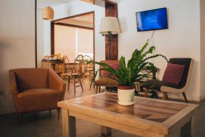 ein Wohnzimmer mit einem Tisch, auf dem eine Pflanze steht in der Unterkunft Hotel Milano in Punta del Este
