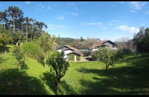 una casa en medio de un campo con árboles en Suites Campestres CDG, en Rio Negrinho