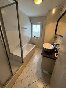 W łazience znajduje się wanna, umywalka i prysznic. w obiekcie Ferienhaus im Thüringer Wald w mieście Struth-Helmershof