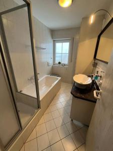 a bathroom with a tub and a sink and a shower at Ferienhaus im Thüringer Wald in Struth-Helmershof