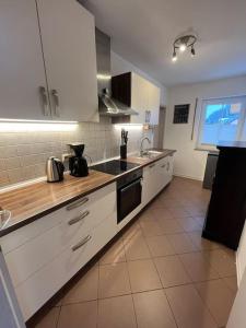 a kitchen with white cabinets and a sink at Ferienhaus im Thüringer Wald in Struth-Helmershof