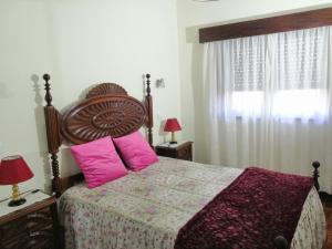 a bedroom with a large bed with pink pillows at L'ALCIBÍADES - Costa Nova in Costa Nova +1 photo