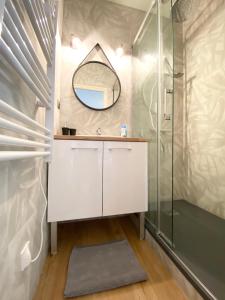 W łazience znajduje się biała toaletka i lustro. w obiekcie LE PTIT STEIR - CALME - WIFI - CENTRE VILLE - ENTREE AUTONOME w mieście Quimper +5 zdjęć
