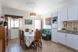 a kitchen and a dining room with a table and a couch at L'ALCIBÍADES - Costa Nova in Costa Nova