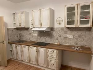 a kitchen with white cabinets and a sink at Byt 4+kk mozanet. in Ústí nad Orlicí