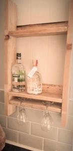 Un estante en un baño con dos botellas. en Barefeet Driftwood Lodge, en St Merryn