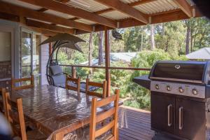 a screened in porch with a table and a grill at Settlement Lodge in Mount Buller