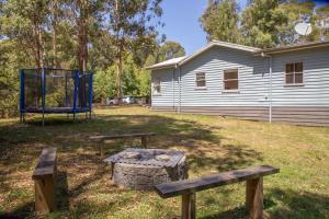 a park with two benches and a basketball hoop at Settlement Lodge in Mount Buller