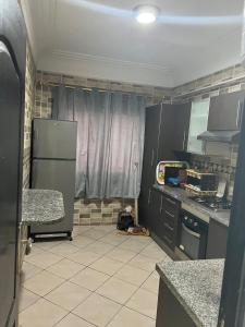 een keuken met een koelkast en een tegelvloer bij Diamant d'atlantic in El Jadida