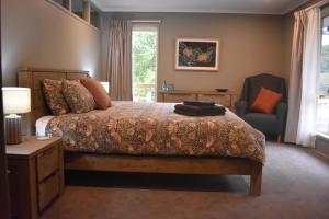 a bedroom with a bed and a chair and a window at Arcadia Views in Witta