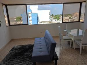 sala de estar con sofá azul y mesa en RH01 Apto en Riohacha con vista a la playa, la mejor zona de la ciudad, genial para trabajar o estar con la familia, en Ríohacha