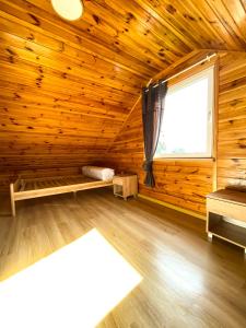 a log cabin with a large window and a wooden floor at Nadmorska Kępa in Kąty Rybackie