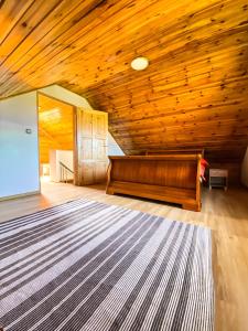 ein Wohnzimmer mit einer Holzdecke und einem Teppich in der Unterkunft Nadmorska Kępa in Kąty Rybackie