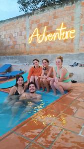 un grupo de personas sentadas en una piscina en The Best Adventure Hostel, en San Gil