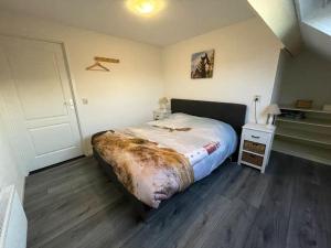 a bedroom with a large bed and a wooden floor at Het Tinkerparadijs, paarden, rust en ruimte. in Burgh Haamstede