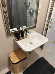 a bathroom with a white sink and a mirror at City Rent 1 in Osijek