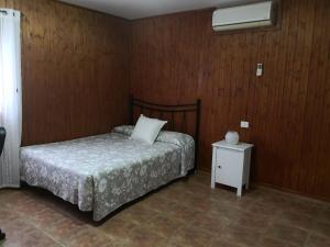 um pequeno quarto com uma cama e uma mesa de cabeceira em Las Moranas em Valsequillo