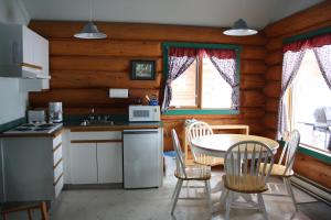 uma cozinha com uma mesa e cadeiras num camarote em Twin Peaks Resort em Valemount
