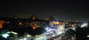 a view of a city at night with lights at primo pyramids inn in Cairo
