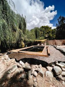 a garden with a pond and a wooden bridge at Cabaña en valle del elqui Horcon in Pisco Elqui