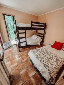 a bedroom with two bunk beds and a wooden floor at Cabaña en valle del elqui Horcon in Pisco Elqui
