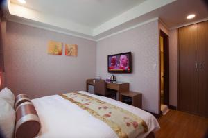 Habitación de hotel con cama y escritorio en True Friend Hotel en Hualien