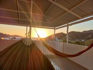 a hammock on a balcony with the sunset in the background at Apartahotel in Taganga