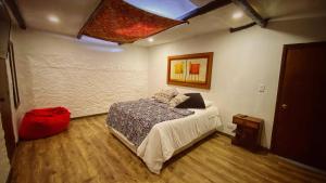 a bedroom with a bed and a painting on the wall at Casa Agrreste in Sopó