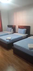 Habitación con 3 camas y sábanas azules. en HOTEL CENTRAL en El Tambo