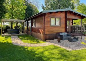 a small cabin with a bench and a gazebo at Oathill Farm Lodges in Winsham