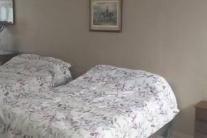 ein Bett mit einer weißen Bettdecke mit Blumen darauf in der Unterkunft Estudio casa del minero in Parral