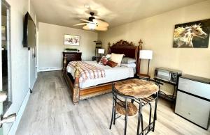1 dormitorio con cama, mesa y TV en Shamrock Cove Inn, en Ocala