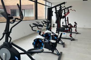 un gimnasio con varias máquinas de cardio en una habitación en Apartaestudio en Chapinero muy bien ubicado, en Bogotá