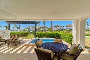 a patio with a table and chairs and a swimming pool at Relax Beach Condo W Private Pool And Beach! in Punta Cana